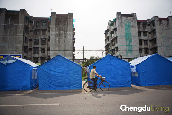 Bicyclist rides past tents